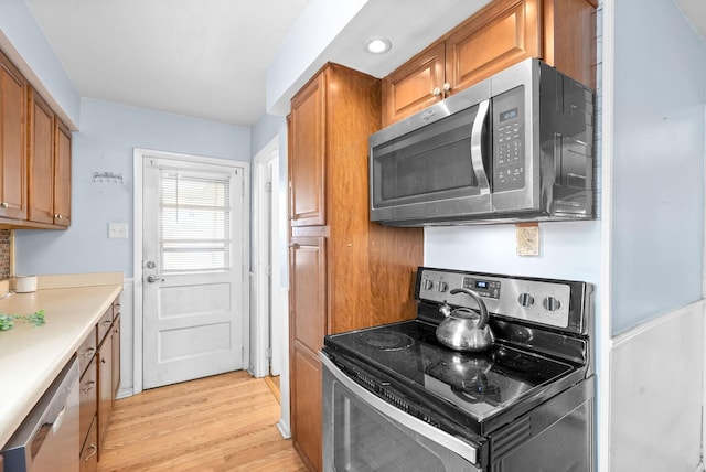 kitchen with light wood-type flooring and appliances with stainless steel finishes