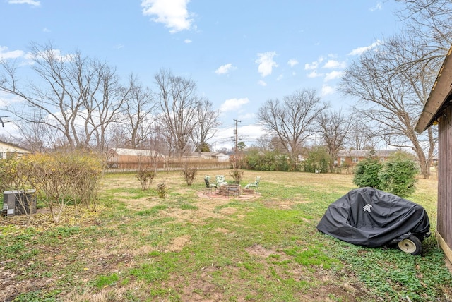 view of yard with an outdoor fire pit and central air condition unit