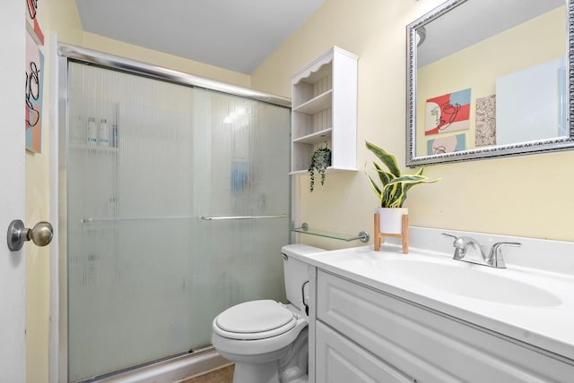 bathroom featuring vanity, an enclosed shower, and toilet