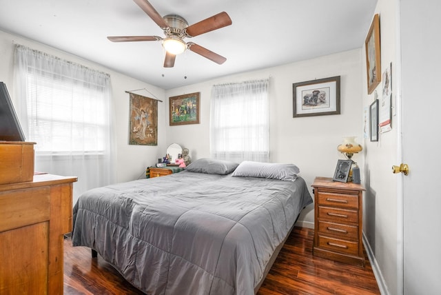 bedroom featuring multiple windows, dark hardwood / wood-style flooring, and ceiling fan