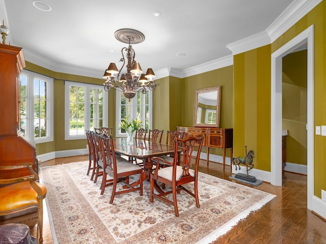 dining room with hardwood / wood-style flooring, ornamental molding, and a chandelier