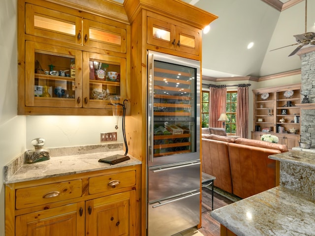 kitchen featuring light stone counters, ceiling fan, a fireplace, wine cooler, and lofted ceiling