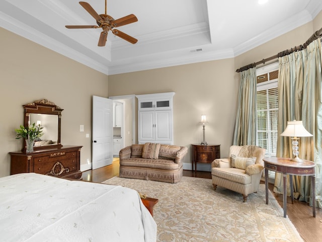 bedroom featuring a raised ceiling, ceiling fan, crown molding, and light hardwood / wood-style floors