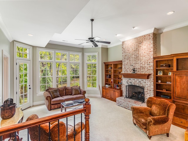 carpeted living room with a brick fireplace, ceiling fan, and crown molding