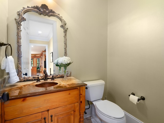 bathroom with vanity, toilet, and crown molding