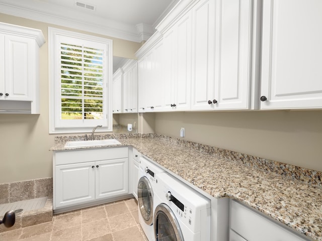 clothes washing area with cabinets, washer and clothes dryer, ornamental molding, and sink