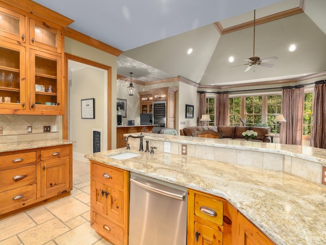 kitchen with stainless steel dishwasher, light stone counters, sink, and tasteful backsplash