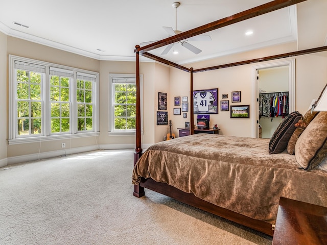 bedroom featuring a walk in closet, crown molding, ceiling fan, light colored carpet, and a closet