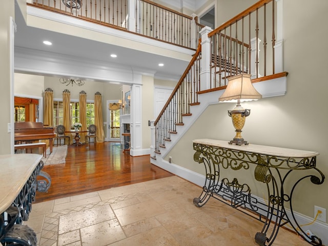 foyer with a high ceiling and crown molding