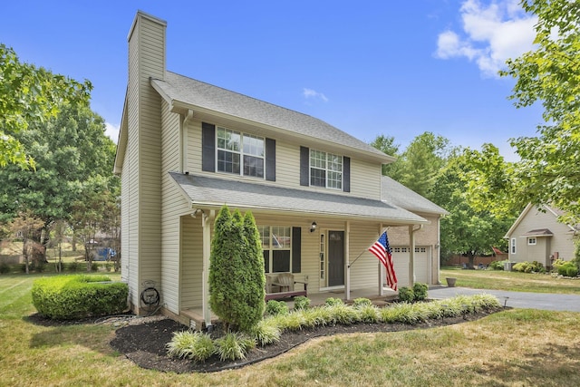 view of front of property featuring a front lawn, a porch, and a garage