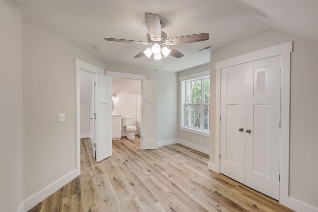 unfurnished bedroom featuring connected bathroom, ceiling fan, light hardwood / wood-style flooring, and lofted ceiling