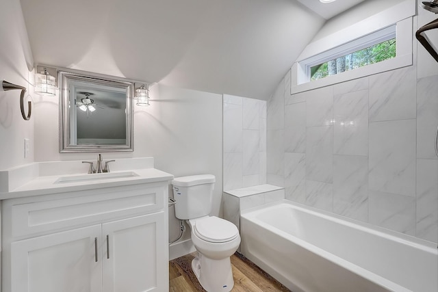 full bathroom with tiled shower / bath combo, vanity, hardwood / wood-style flooring, toilet, and lofted ceiling