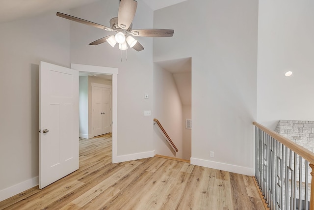 empty room featuring ceiling fan, light wood-type flooring, and lofted ceiling