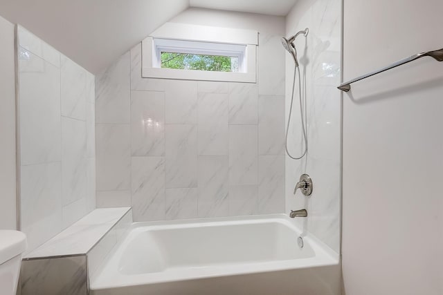 bathroom featuring tiled shower / bath combo and toilet