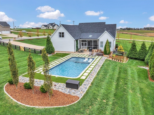 view of swimming pool featuring a lawn, a sunroom, and a patio