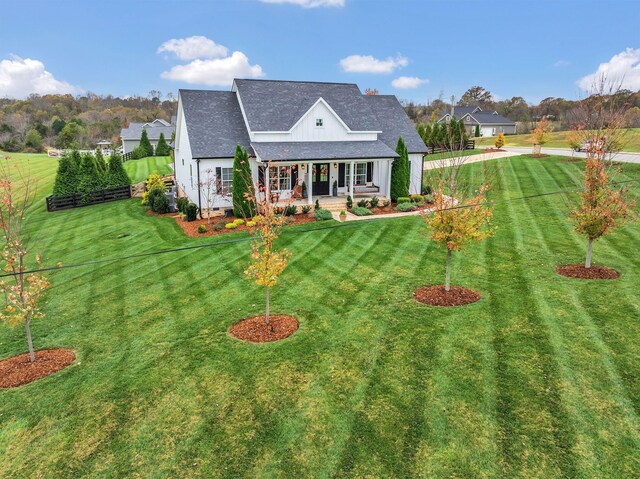 back of house featuring a porch and a yard