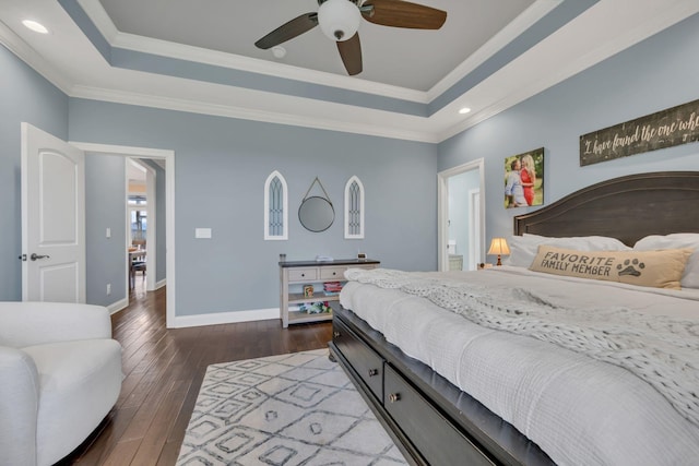 bedroom featuring dark hardwood / wood-style flooring, a tray ceiling, ceiling fan, and crown molding