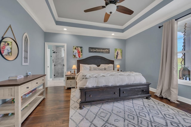 bedroom featuring ensuite bathroom, a tray ceiling, ceiling fan, crown molding, and dark hardwood / wood-style floors