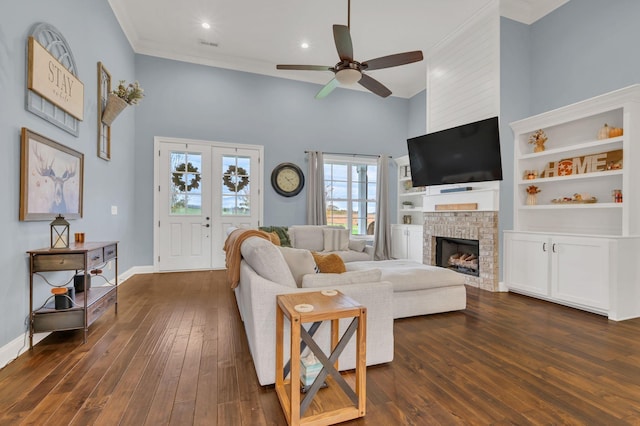 living room featuring ceiling fan, a fireplace, dark hardwood / wood-style floors, and ornamental molding