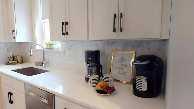 kitchen featuring dishwasher, decorative backsplash, white cabinetry, and sink