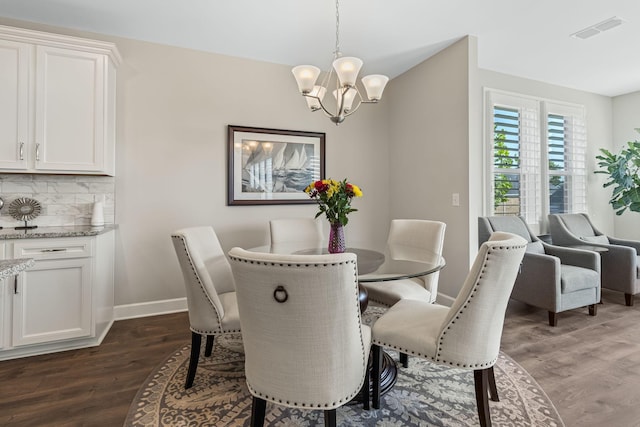 dining area featuring dark hardwood / wood-style floors and a chandelier