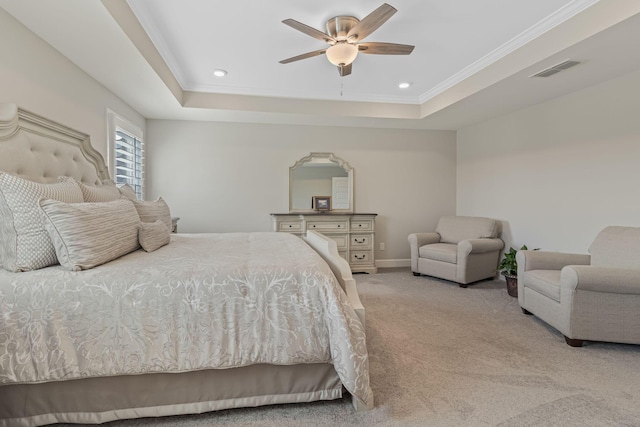 carpeted bedroom featuring a tray ceiling, ceiling fan, and ornamental molding