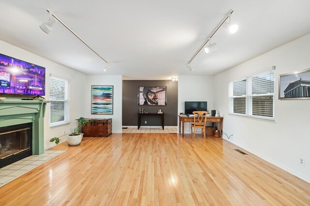 3417 Pleasant Valley Rd, Nashville, TN 37204 - living room featuring a tile fireplace, wood-type flooring, and track lighting