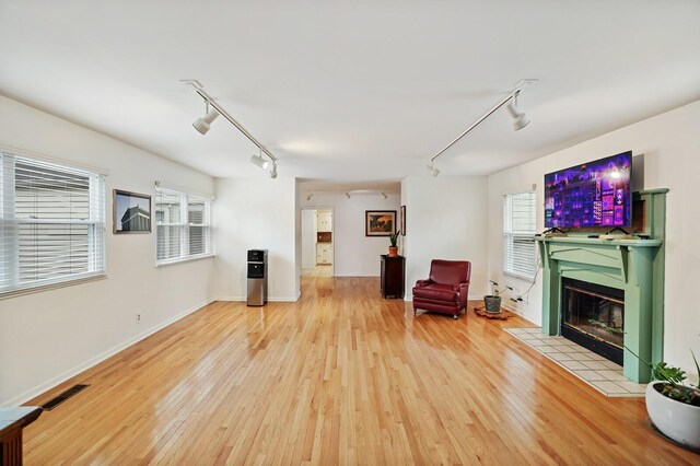 3417 Pleasant Valley Rd, Nashville, TN 37204 - unfurnished room with a tile fireplace, track lighting, and hardwood / wood-style flooring
