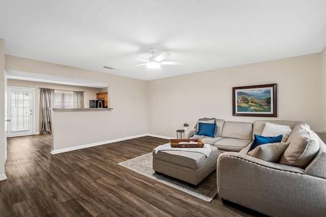 living room featuring dark hardwood / wood-style flooring and ceiling fan