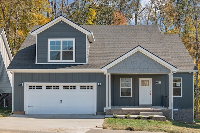 view of front facade featuring driveway, a porch, board and batten siding, and an attached garage