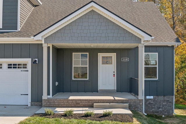 doorway to property with covered porch and a garage