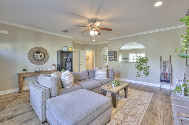 living room with hardwood / wood-style floors, ceiling fan, and crown molding