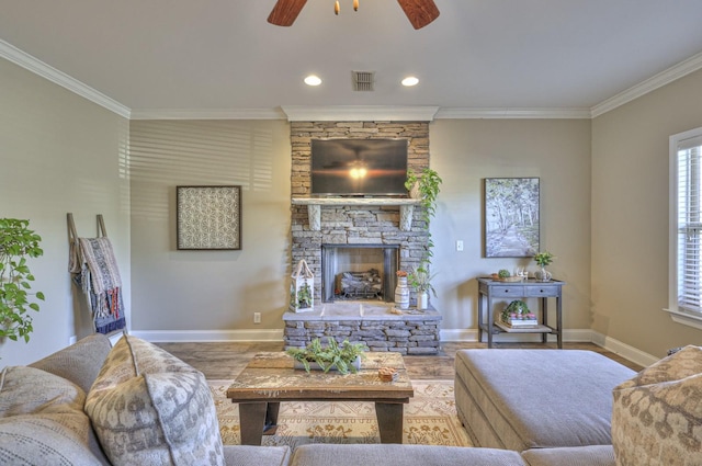 living room with a fireplace, hardwood / wood-style floors, ceiling fan, and crown molding