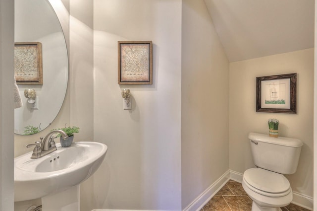 bathroom featuring sink, tile patterned flooring, vaulted ceiling, and toilet