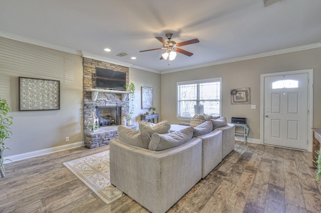 living room with a fireplace, hardwood / wood-style floors, ceiling fan, and crown molding