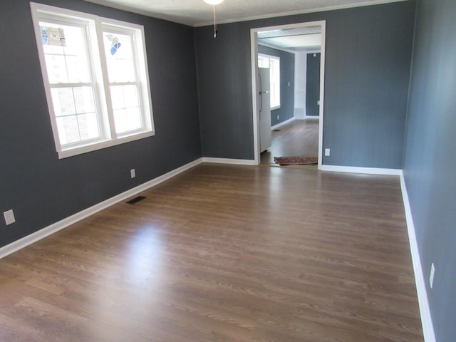 unfurnished room featuring ceiling fan, crown molding, and dark wood-type flooring