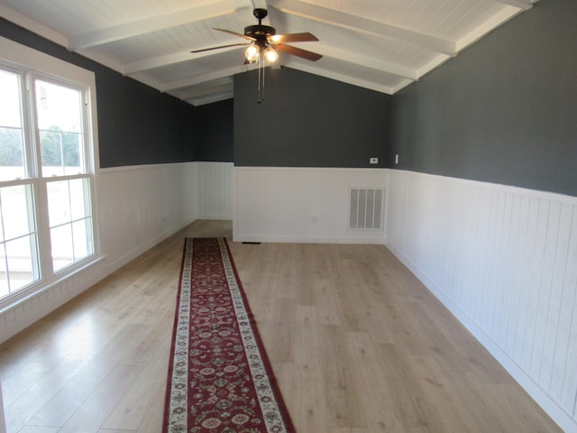 unfurnished room featuring ceiling fan, light hardwood / wood-style flooring, and lofted ceiling with beams