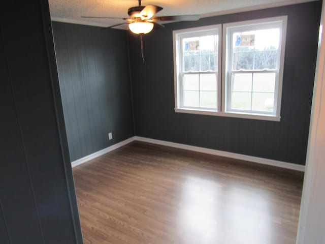 empty room with hardwood / wood-style flooring, a wealth of natural light, and ceiling fan