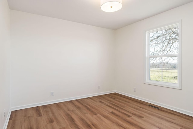 unfurnished room featuring hardwood / wood-style floors and a healthy amount of sunlight