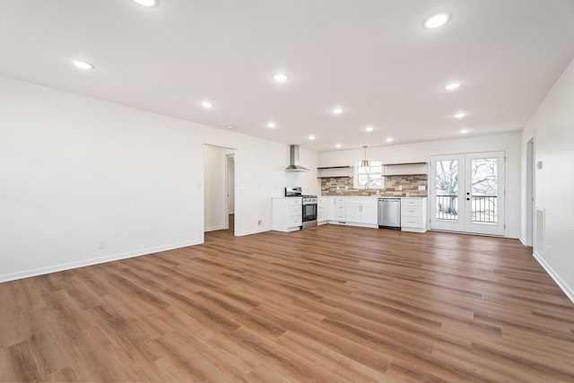 unfurnished living room with wood-type flooring, french doors, and sink