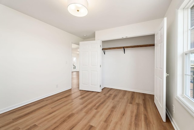 unfurnished bedroom with a closet and light wood-type flooring