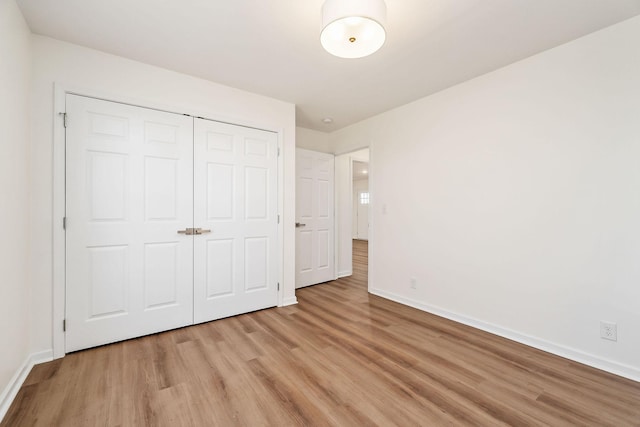 unfurnished bedroom with a closet and light wood-type flooring