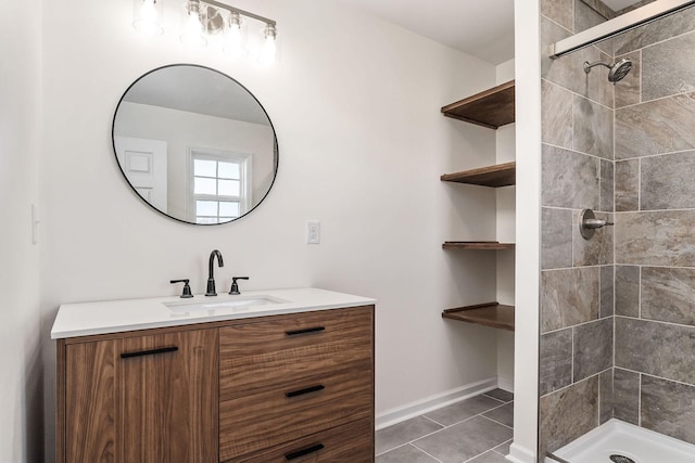 bathroom with tile patterned flooring, vanity, and tiled shower