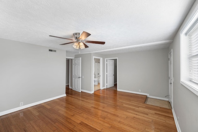 unfurnished room with ceiling fan, hardwood / wood-style floors, and a textured ceiling