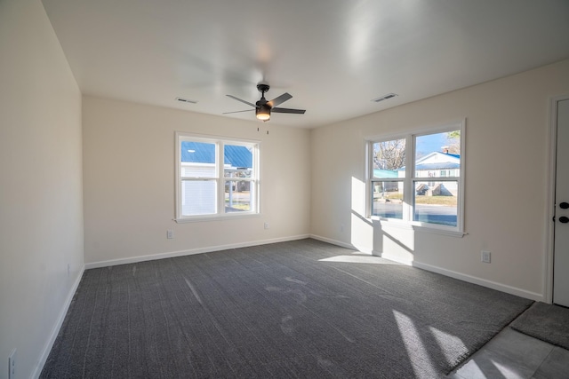 spare room with ceiling fan and dark carpet