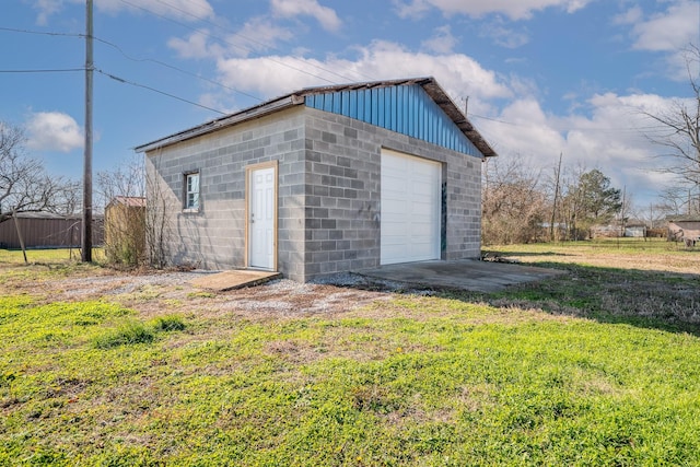 view of outdoor structure featuring a lawn and a garage