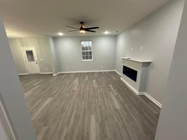 unfurnished living room with hardwood / wood-style flooring and ceiling fan