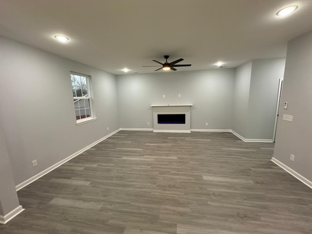 unfurnished living room with ceiling fan and dark hardwood / wood-style flooring