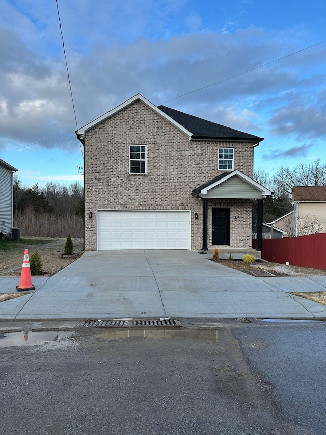 view of front property with a garage and central AC unit