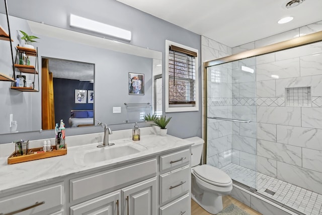 bathroom with vanity, toilet, and a shower with shower door